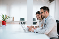 GettyImages-931182764 Cheerful Office Workers On Laptops