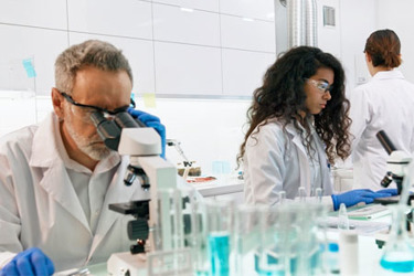 Scientists And Microscopes GettyImages-1275317360