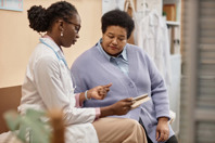 Female Patient Listening to Doctor Holding Tablet-GettyImages-1947527002