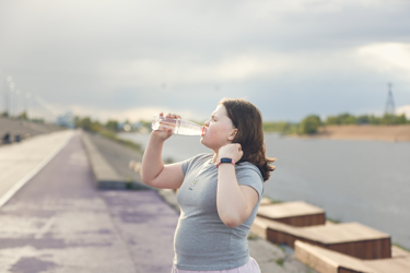 Overweight Teenage Girl Drinking Water From Bottle