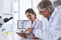 Scientists In Lab Working Together On Digital Tablet GettyImages-893884830