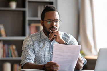 African student guy sit at desk hold papers-iStock-1253877173 African student guy sit at desk hold papers-iStock-1253877173