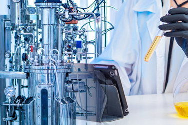 GettyImages-2155418067-bioreactor-scientist-ipad-beaker