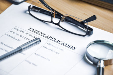 GettyImages-1788431592-patent-application-desk-glasses-pen-paper GettyImages-1788431592-patent-application-desk-glasses-pen-paper