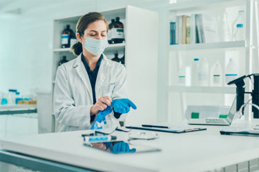 GettyImages-1287845246-laboratory-bottles-mask-scientist-gloves-coat