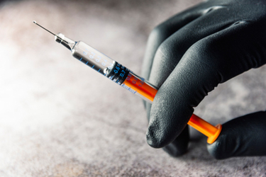 iStock-1283232421-syringe-glove-hand-injection